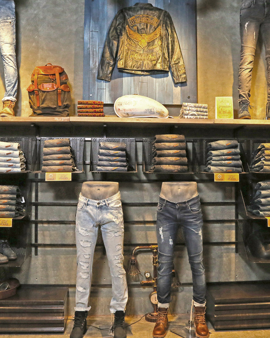 Retail brand identity execution highlighting visual merchandising of jeans and jackets using industrial fixtures in a branded retail environment by JUMPINGGOOSE.