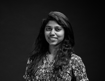 Monochrome portrait of Jesli, a member of the JUMPINGGOOSE creative team, paired with a high-contrast magenta overlay introducing her as 'The Print Maestro'.