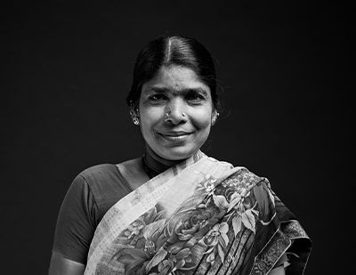 Expressive black-and-white portrait of Mala in a sari with a subtle smile, combined with a bold typographic overlay reading 'MALA – The Zen Barista'.