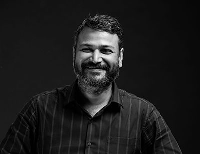 Black-and-white portrait of Saket smiling against a dark background, paired with a bold typographic slide reading 'Saket – The Pixel Picasso'.